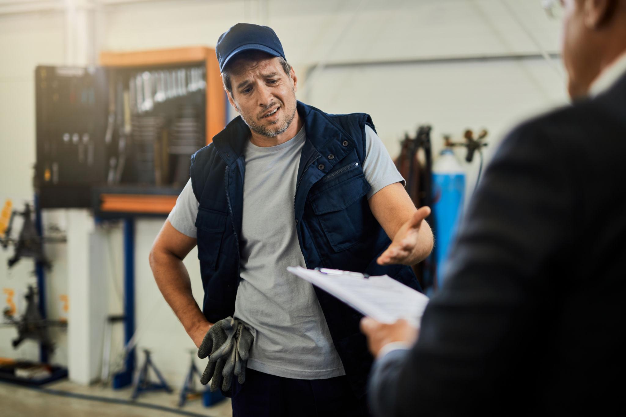 Mécanicien annonçant une incompatibilité de pièce auto au client
